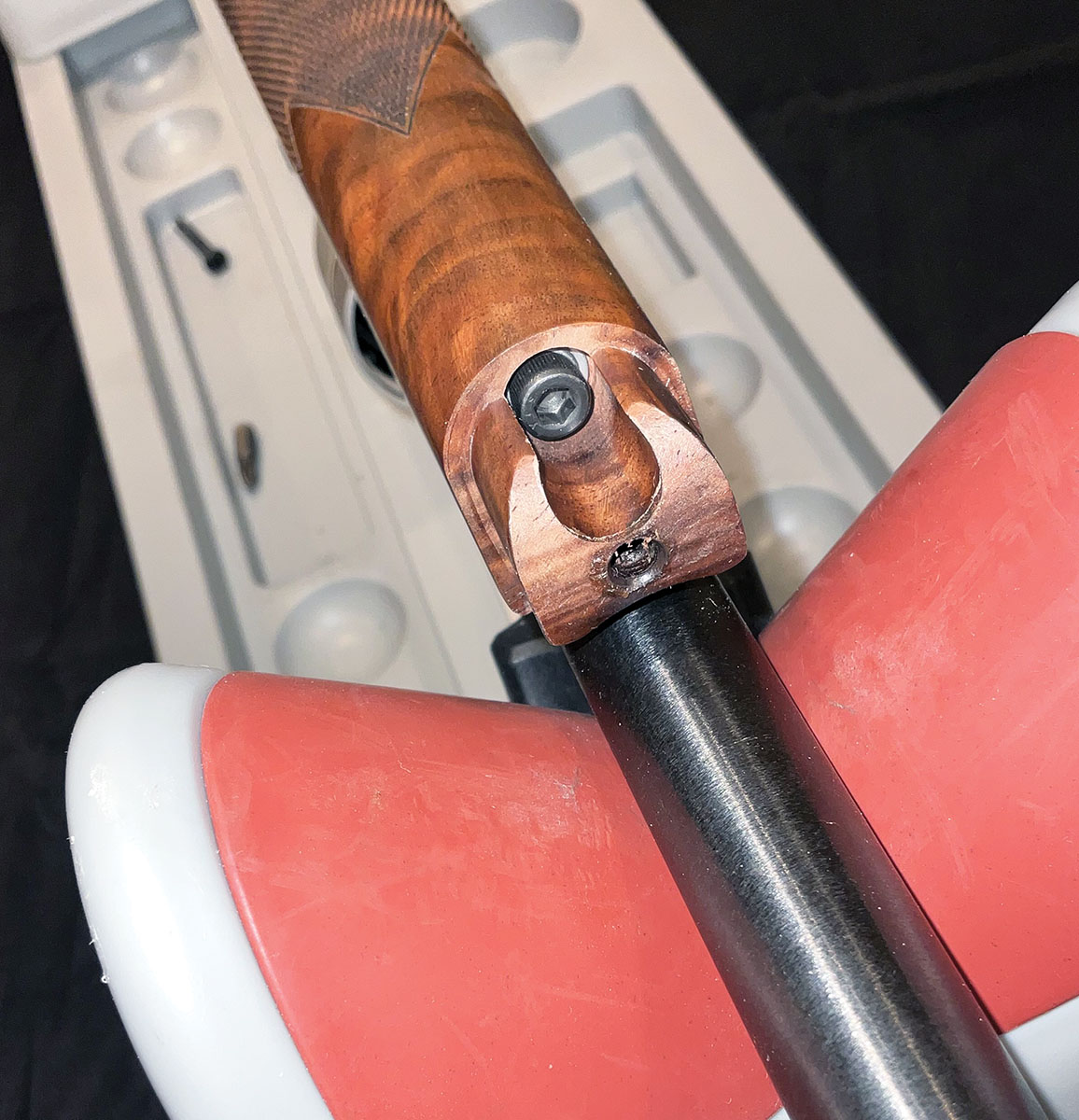 A strut rod fastens the walnut forearm to the receiver.